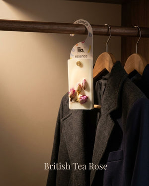 wax sachet from lila with love infused with dried rose buds hanging on a wooden hanger on wooden wardrobe with cloths around them