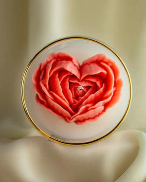 a candle with Heart-shaped rose design on a white background with a gold rim by lila with love