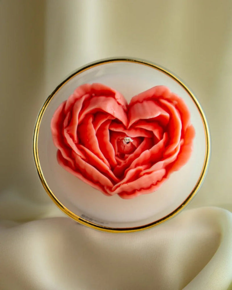 a candle with Heart-shaped rose design on a white background with a gold rim by lila with love