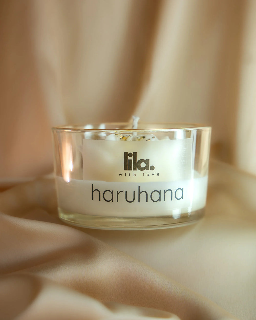 Haruhana white floral soy wax candle with gold foil flakes in glass jar by Lila with Love on a beige background