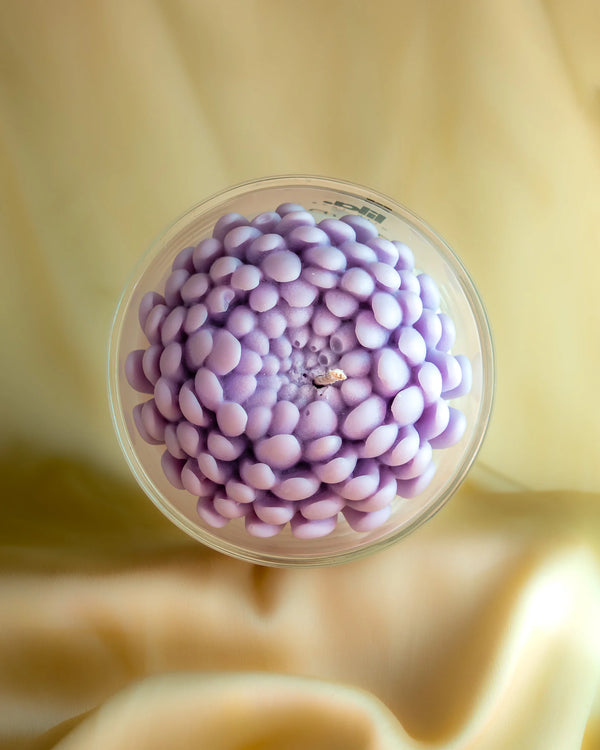 Insane soy wax candle with purple petal design in clear glass jar, held by hand, from Lila with Love