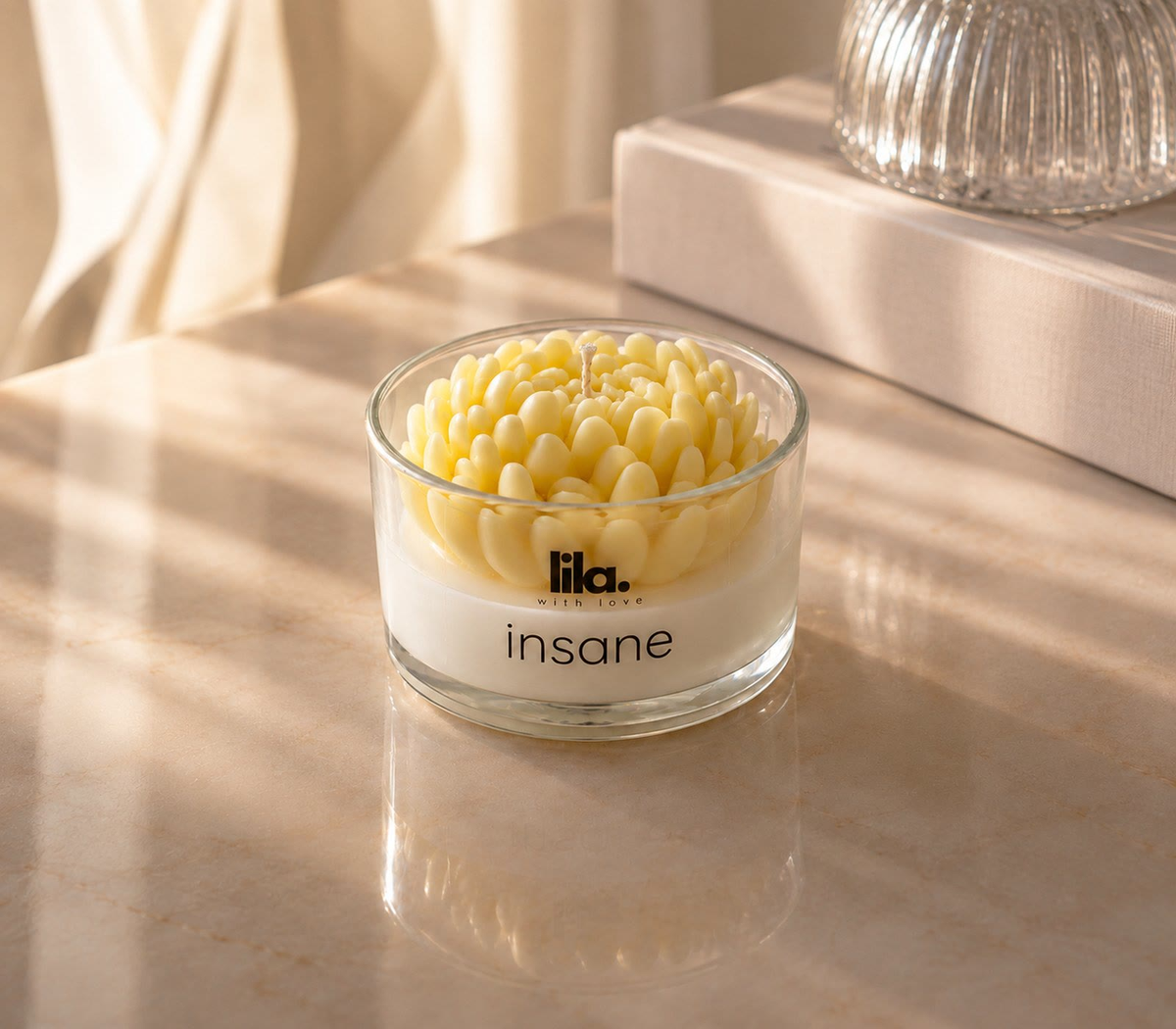 Insane, a sculpted floral Lila candle, on sunlit marble