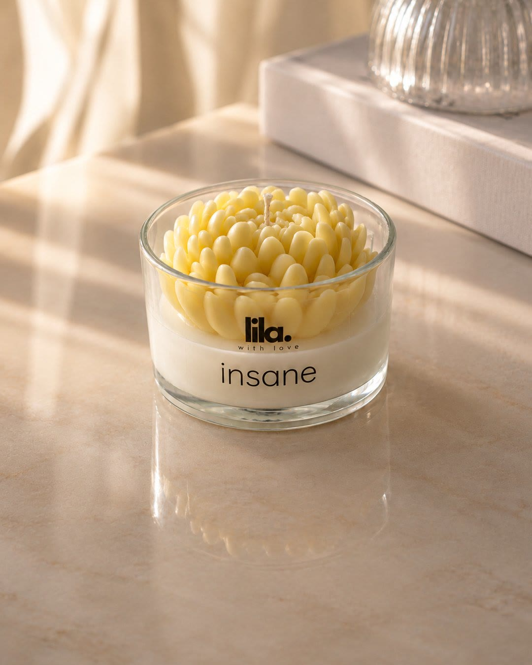 Insane, a sculpted floral Lila candle, on sunlit marble