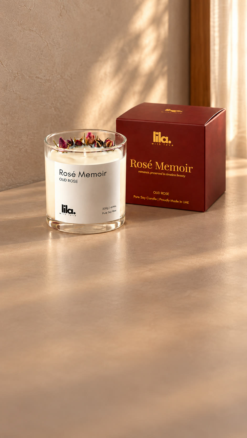 Rosé Memoir candle topped with dried rosebuds beside its burgundy gift box