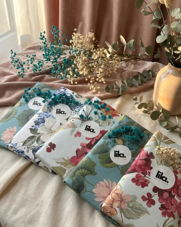 Floral-patterned products with 'lila' branding on a soft surface with decorative elements.