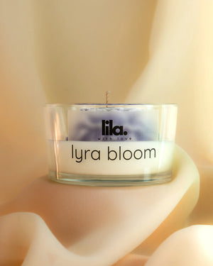 pink layered flower soy wax candle in clear glass jar by Lila with Love, top view on satin background