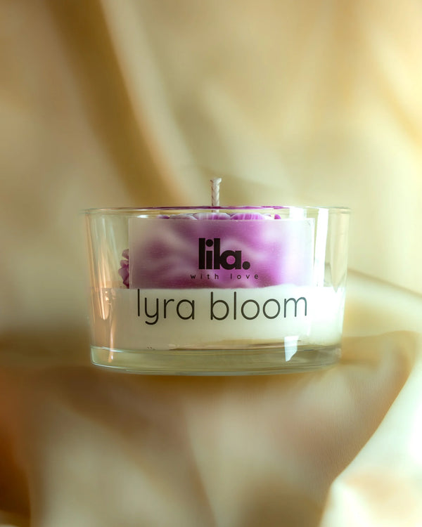 Candle in a glass jar with 'lyra bloom' branding from lila with love on a soft beige background