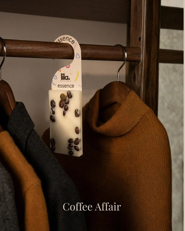 wax sachet from lila with love infused with coffee beans hanging on a wooden hanger on wooden wardrobe with cloths around them