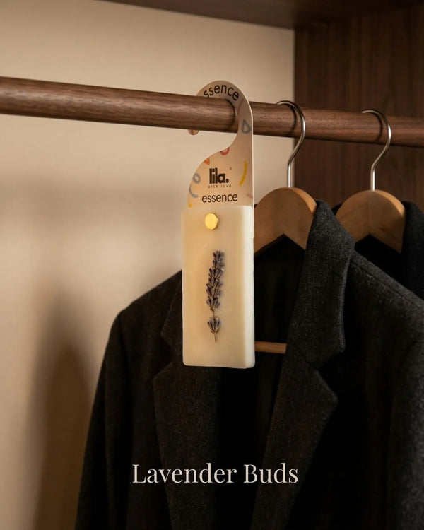 wax sachet from lila with love with lavender buds  hanging on a wooden hanger on wooden wardrobe with cloths around them