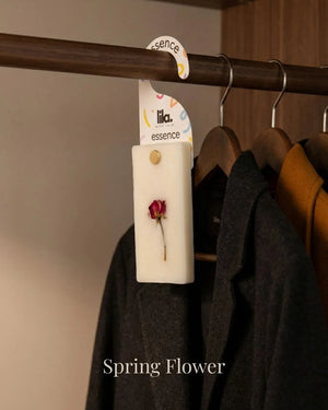 wax sachet from lila with love infused with dried flower hanging on a wooden hanger on wooden wardrobe with cloths around them