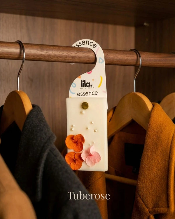 wax sachet from lila with love infused with colorful flowers hanging on a wooden hanger on wooden wardrobe with cloths around them