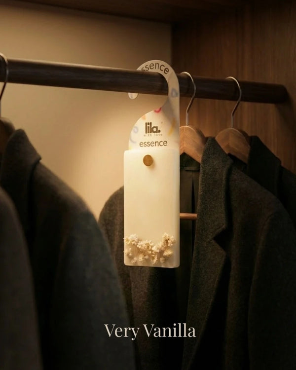 wax sachet from lila with love with white babys breath  buds  hanging on a wooden hanger on wooden wardrobe with cloths around them